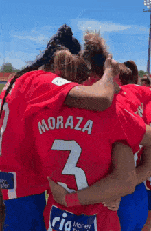 a group of female soccer players are huddled together and one of them is wearing a jersey that says moraza 3