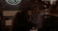 a woman is dancing in front of a sign for grey 's anatomy