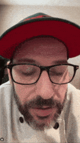 a man with glasses and a beard wearing a hat