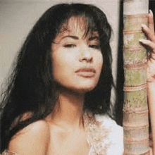 a close up of a woman holding a palm tree .