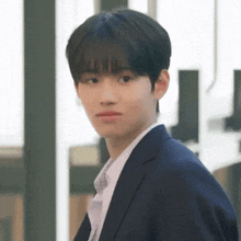 a young man in a suit and tie is making a funny face .