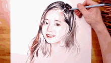 a person is drawing a woman 's face with a colored pencil