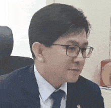 a man in a suit and tie is sitting in a chair .