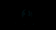 a man is sitting at a desk with his head on his knees in a dark room .