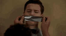 a man is duct taped to another man 's mouth .