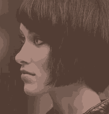 a close up of a woman 's face with short hair and a fringe