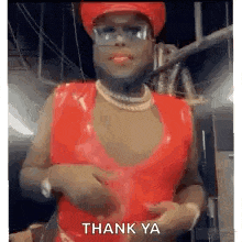 a man in a red dress is wearing a red hat and glasses and says `` thank ya '' .