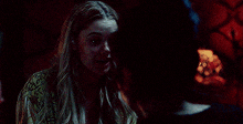 a woman is standing in a dark room with a man behind her
