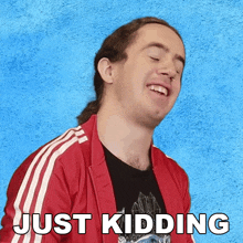 a man in a red jacket is laughing with the words just kidding written below him