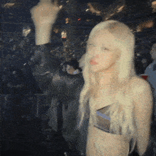 a woman in a crop top is standing in front of a crowd