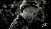 a black and white photo of a man wearing a hat with kala malam mengambang on the bottom