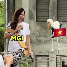 a woman is standing next to a stork with a vietnamese flag on its head and the word mgi on her shirt