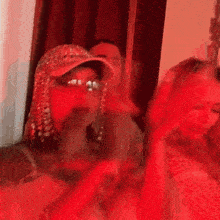 a blurry photo of a group of people dancing in a room with red lights .