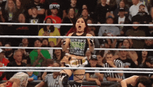 a woman in a wrestling ring wearing a tank top that says rocks on it