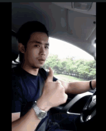 a man in a car giving a thumbs up