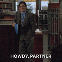 a man in a suit and tie is standing in front of a counter that says howdy partner