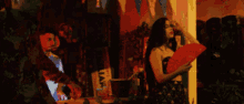 a woman in a black dress is holding a red fan with the letter t on the front