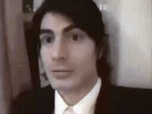 a man in a suit and tie is looking at the camera in a blurry photo
