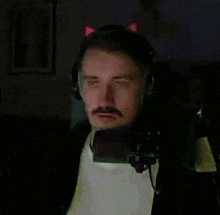 a man with a mustache wearing headphones and a cat ear headset
