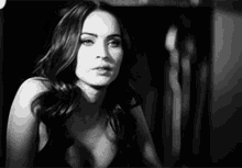 a black and white photo of a woman in a plunging neckline .