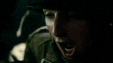 a close up of a person 's face in a dark room with their mouth open .