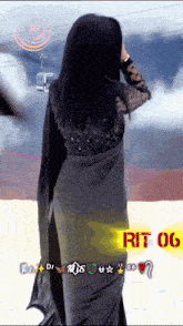 a woman in a black saree is standing in the snow