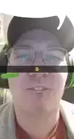 a man wearing glasses and a green headset with a smiley face on it