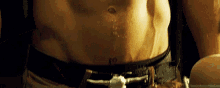 a close up of a man 's stomach with a tattoo on it and a belt .
