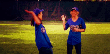 two female baseball players wearing jerseys with the number 9 on them