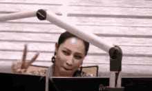 a woman is giving a peace sign in front of a computer screen .