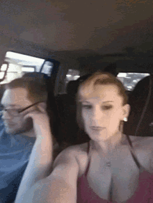 a man and a woman are sitting in the back seat of a car