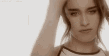 a close up of a woman holding her hair in her hand .