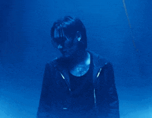 a man in a black jacket is standing in the water