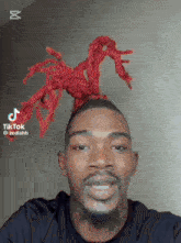 a man with a beard and red dreadlocks on his head is smiling .