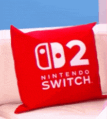 a red nintendo switch pillow is on a white couch