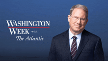 a man in a suit and tie stands in front of a washington week with the atlantic banner