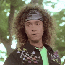 a man with curly hair is wearing a headband