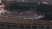 an aerial view of a race track with a crowd in the stands watching