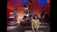 a group of people are playing instruments on a stage and a woman is playing a keyboard .
