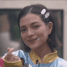 a close up of a woman making a heart shape with her fingers
