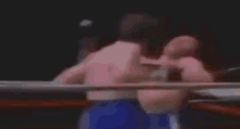 a blurry picture of a boxing match with a referee standing in the corner .