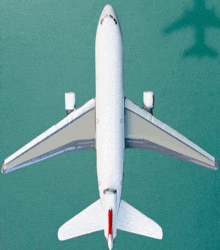 a white airplane with a red tail is flying over the ocean