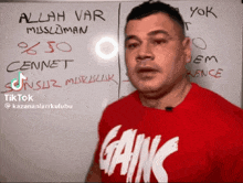 a man wearing a red shirt with gains written on it