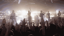 a group of people on a stage with their hands up