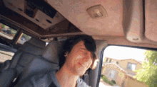 a man is sitting in the back seat of a car and smiling