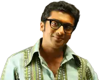 a man wearing glasses and a patterned shirt looks at the camera