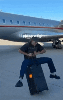 a man is sitting on a suitcase in front of an airplane with the words i 'll put up a fight on the bottom