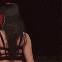a woman in a black tank top and red shorts is dancing in a dark room .