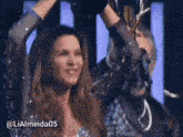 a woman holding a trophy in her hands with the hashtag lialmeida05 on the bottom