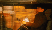 a man driving a car with a steering wheel